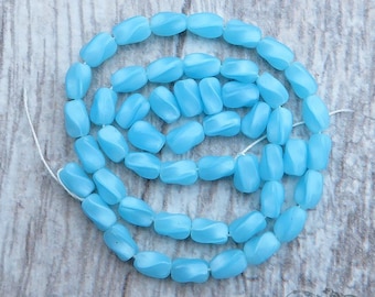 Strand of 1940&#39;s vintage Czech twist beads in pale satin blue. 50 pressed glass 4x6 mm oval tubes with semi translucent moonstone effect.