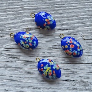 Vintage Japanese millefiori glass pendants in royal blue with multicolor flowers. 15x21 mm oval Tombo glass charms drops w/ gold metal loop.