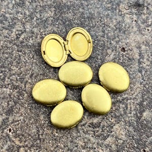 May include: Seven gold-toned oval locket charms with a hinged opening. The lockets are smooth and have a slightly textured finish.
