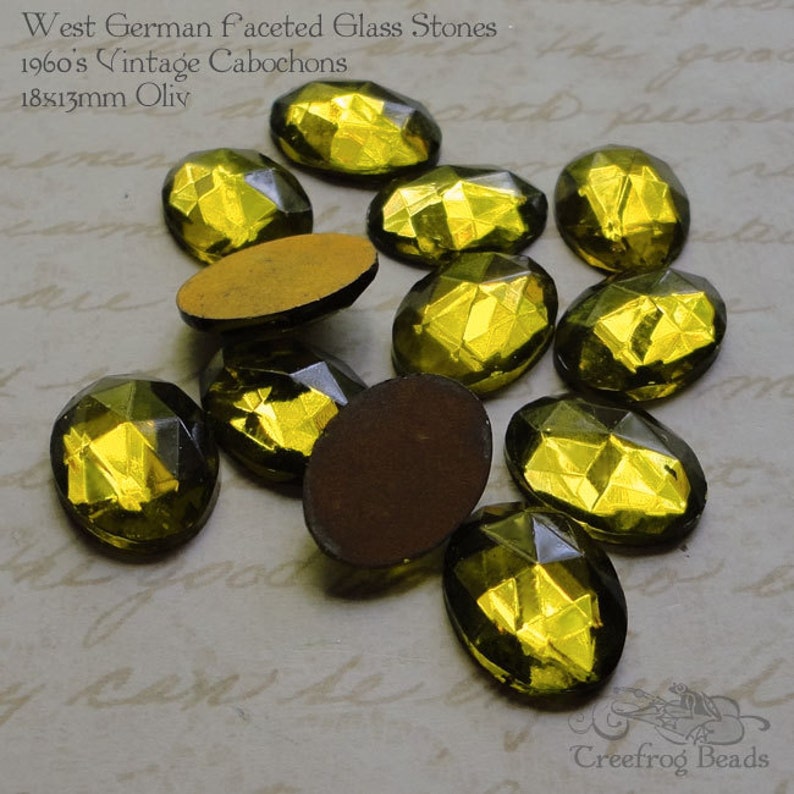 May include: A group of 10 oval-shaped, faceted glass stones in a yellow-green color. The stones are approximately 18x13mm and are described as "West German faceted glass stones 1960's vintage cabochons 18x13mm Oliv".