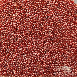 May include: A close-up image of a large quantity of small, round, red glass beads. The beads have a shiny, metallic finish.
