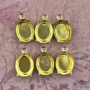10x8 mm raw brass cabochon settings with 4 prongs and a single top loop. 12 pc lot of  vintage brass findings for 8x10 oval stones.