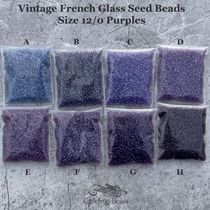 May include: Eight small bags of purple and blue glass seed beads, labeled A through H. The beads are size 12/0. The text "Vintage French Glass Seed Beads Size 12/0 Purples" is at the top of the image.