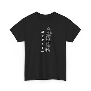 May include: Black t-shirt featuring a white line drawing of a basketball player shooting a ball. The word "MONEY" is printed vertically in white, with the word "MERRILL" below the drawing.