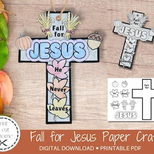 May include: Two cross-shaped paper crafts with fall-themed decorations. One is colored with the words "Fall for Jesus," "He Never Leaves," and a pumpkin and acorn. The other is a black and white outline. The words "Fall for Jesus Paper Craft" are at the bottom.