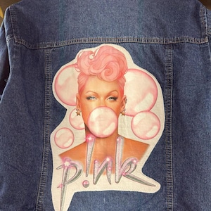 Ladie&#39;s denim jacket with Pink photo on the back. Ladie&#39;s Galt Brand denim jacket, with Pink tee attached to the back. Faded Glory Brand, XL