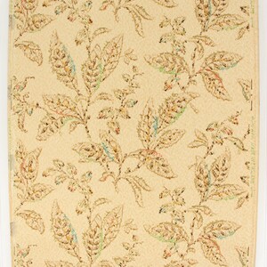 May include: Vintage wallpaper with a repeating pattern of brown, green, and blue leaves on a cream background. The wallpaper has a textured surface and is made in England.