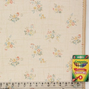Puede incluir: Papel tapiz vintage con un delicado patr&oacute;n floral en tonos amarillos, rojos y azules sobre un fondo crema. El papel tapiz tiene un sutil patr&oacute;n de cuadr&iacute;cula.