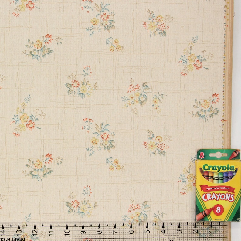 Puede incluir: Papel tapiz vintage con un delicado patr&oacute;n floral en tonos amarillos, rojos y azules sobre un fondo crema. El papel tapiz tiene un sutil patr&oacute;n de cuadr&iacute;cula.