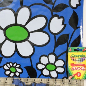 Puede incluir: Papel de regalo con estampado floral azul y blanco con una caja de 8 crayones Crayola. Los crayones son rojo, naranja, amarillo, verde, azul, morado, marr&oacute;n y negro. La caja dice "Crayola Crayones &iexcl;Preferidos por los Maestros!"