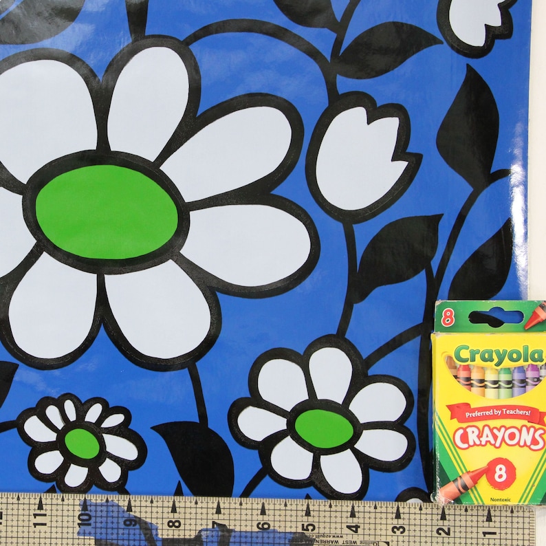 Puede incluir: Papel de regalo con estampado floral azul y blanco con una caja de 8 crayones Crayola. Los crayones son rojo, naranja, amarillo, verde, azul, morado, marr&oacute;n y negro. La caja dice "Crayola Crayones &iexcl;Preferidos por los Maestros!"