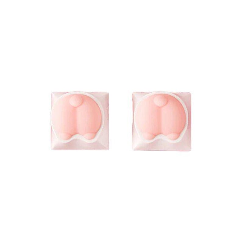 May include: Two pink bunny butt keycaps with a white outline. The keycaps are square and have a raised, rounded shape.