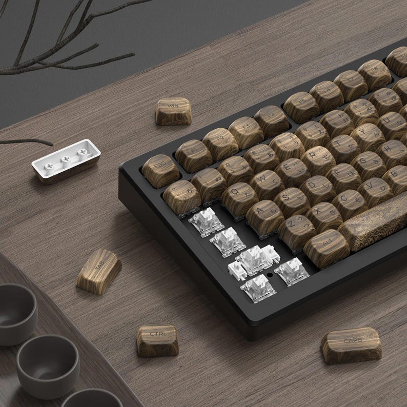 Pu&ograve; includere: Una tastiera in legno con tasti marroni e una cornice nera. I tasti hanno lettere bianche e includono tasti come "WIN", "TAB", "CTRL" e "CAPS".