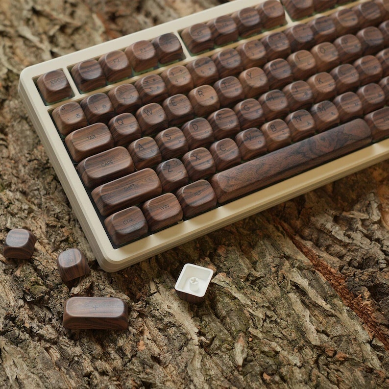 Pu&ograve; includere: Una tastiera in legno con tasti marroni e una cornice bianca. La tastiera &egrave; su una superficie in legno marrone. Ci sono diversi tasti extra sulla superficie.