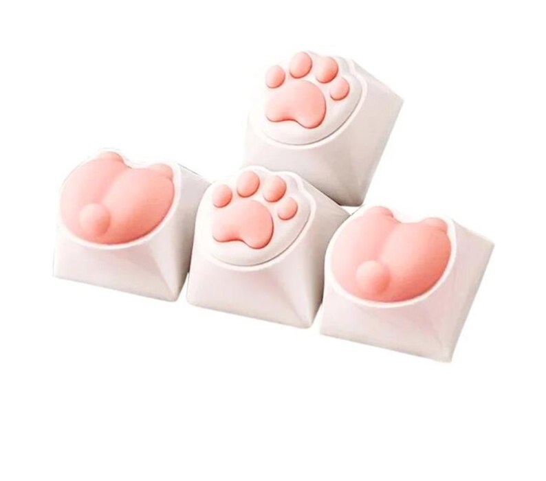 May include: Four white keycaps with pink paw print and paw designs. The keycaps are for a mechanical keyboard.