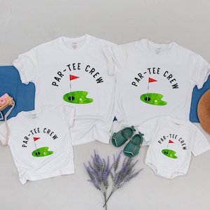 May include: Four white t-shirts with the text "Par-Tee Crew" and a green golf course with a red flag. The shirts are in different sizes, with the smallest being a onesie.