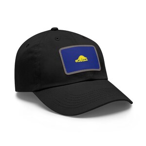 May include: Black baseball cap with a rectangular patch featuring a blue background and a yellow turtle design. The patch is outlined in gray. The cap has a curved brim and a button on top.