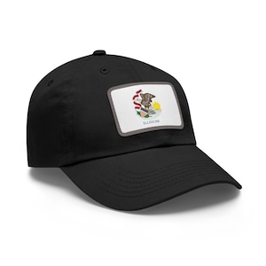 Op de afbeelding: Zwarte baseballpet met een rechthoekige patch met het zegel van de staat Illinois. De patch bevat een Amerikaanse zeearend, het staatsmotto en het woord "ILLINOIS". De pet heeft een gebogen klep.