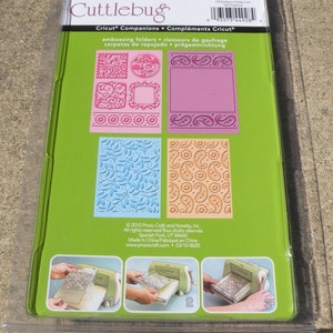 May include: A green and white package for a Cuttlebug embossing folder set. The package shows four different designs: a paisley pattern, a floral pattern, a frame, and a circle. The package includes instructions for using the embossing folders with a Cricut machine.