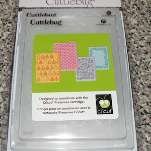 May include: Cuttlebug embossing folders in a clear plastic package. The package includes several embossing folders with various designs, including pears, circles, and floral patterns. The package is designed to coordinate with the Cricut Preserves cartridge.