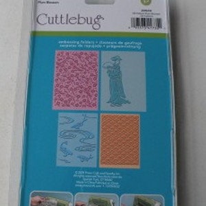 May include: Cuttbug embossing folders, a set of four, with two floral patterns and two geometric patterns. The packaging shows a woman holding a bouquet of flowers, a pattern of fish, and a geometric pattern.