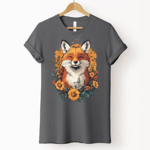 una maglia color asfalto con l'immagine di una volpe sorridente circondata da fiori in stile cottagecore