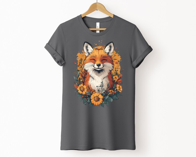 una maglia color asfalto con l'immagine di una volpe sorridente circondata da fiori in stile cottagecore