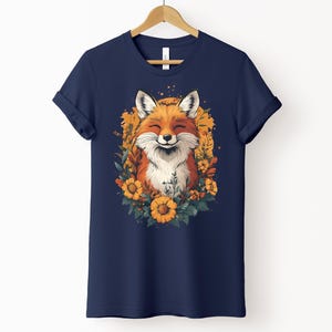 una maglia color marina militare con l'immagine di una volpe sorridente circondata da fiori in stile cottagecore