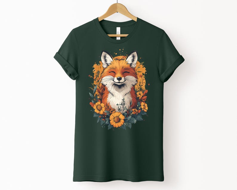 una maglia color verde foresta con l'immagine di una volpe sorridente circondata da fiori in stile cottagecore
