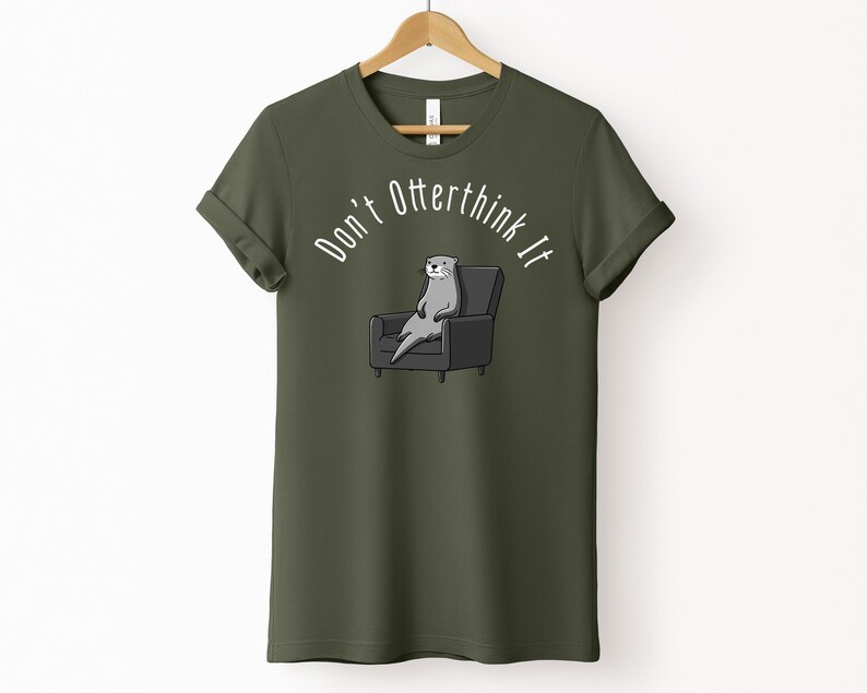 una tshirt color verde militare con una lontra su una poltrona e sopra di lei la scritta "Don't otterthink it"