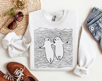 Sudadera con estampado de una linda pareja de nutrias nadando, camiseta unisex para amantes de la naturaleza, regalo para ella.