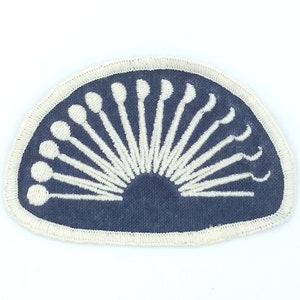 May include: A blue embroidered patch with a white design of a half circle of dental tools.