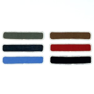 May include: Six fabric patches in different colours. The patches are rectangular and have a white border. The colours are green, brown, red, blue, and black.