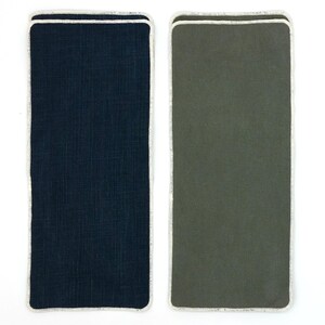 Peut inclure: Deux sets de table rectangulaires en tissu avec une bordure blanche. Le set de table de gauche est bleu foncé et le set de table de droite est vert foncé.