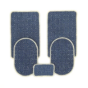 Pode incluir: Um conjunto de seis tapetes de casa de banho com padrões azuis e brancos. Os tapetes são de várias formas e tamanhos, incluindo retangulares, ovais e um pequeno tapete retangular. Cada tapete tem uma borda branca e um design geométrico repetitivo.