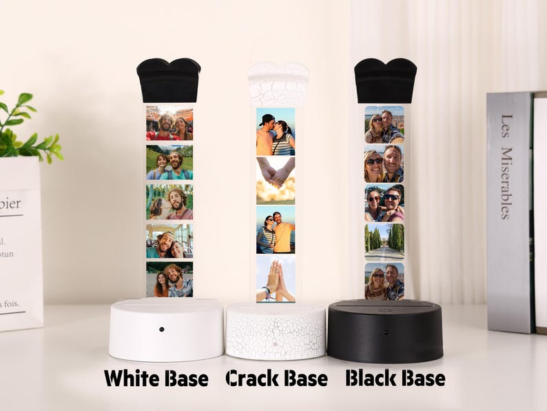 Pu&ograve; includere: Tre lampade espositive fotografiche con basi bianche, screpolate e nere. Ogni lampada presenta una serie di piccole foto e una parte superiore a forma di cuore. Le basi sono rotonde con un piccolo pulsante. Il testo "White Base", "Crack Base" e "Black Base" &egrave; in basso.