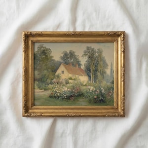 Puede incluir: Pintura enmarcada de una casa de campo con tejado rojo, rodeada de exuberante vegetación y flores coloridas. La pintura está enmarcada en un marco dorado y ornamentado, creando una estética vintage. La obra representa una escena de paisaje serena.