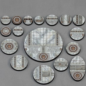 May include: A collection of circular and oval miniature bases featuring a white marble tile floor pattern with gold-toned lion head emblems and black borders. Several bases include Latin text inscriptions printed on the surface in a dark font.