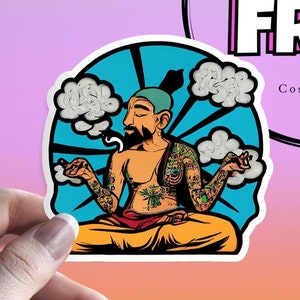 Può includere: Un adesivo circolare raffigurante una persona tatuata con barba e berretto color ottanio seduta in posizione meditativa. La persona è circondata da nuvole bianche su uno sfondo blu brillante con linee radiali nere nel disegno.