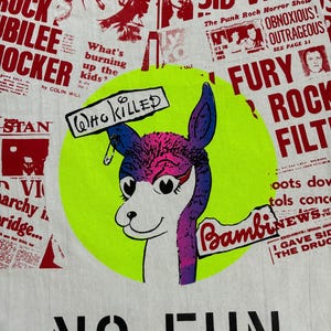 May include: White t-shirt with a neon green circle featuring a colorful llama graphic. The llama has purple, pink, and blue fur and holds signs that read "Who Killed" and "Bambi News". The shirt also has the words "No Fun" printed in black.