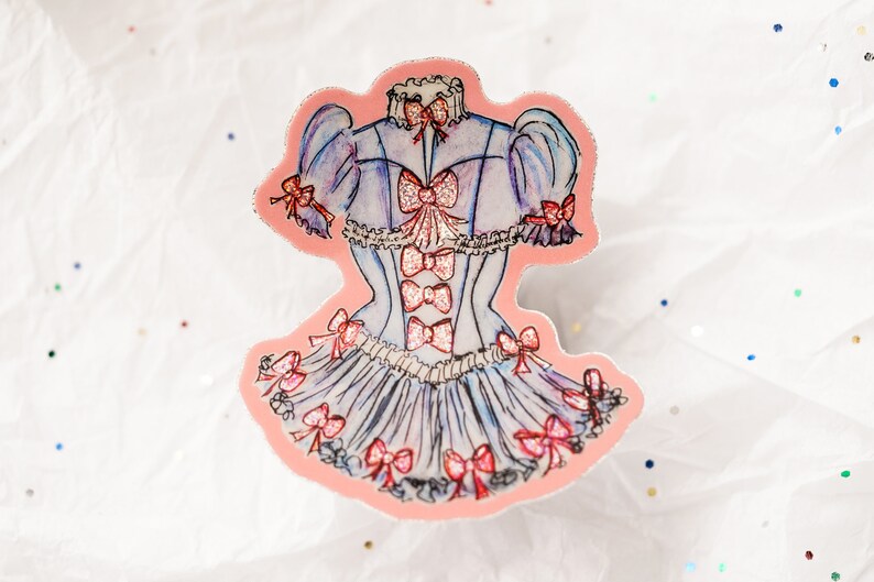 K&ouml;nnte beinhalten: Ein Aufkleber mit einer Aquarellillustration eines hellblauen Kleides mit rosa Schleifen und Glitzerakzenten. Das Kleid hat ein Korsett-Oberteil und einen ger&uuml;schten Rock, mit Schleifen an &Auml;rmeln und Ausschnitt.