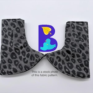 May include: Two gray and black leopard print fabric covers with a vertical slit opening on each piece. A purple logo featuring a yellow leaf and two blue birds is positioned between the covers, with text stating: This is a stock photo of this fabric pattern.