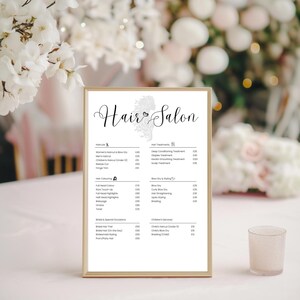May include: A white framed price list for a hair salon with the title "Hair Salon" at the top. The price list includes services such as haircuts, hair coloring, blow dry & styling, hair treatments, and children's services.
