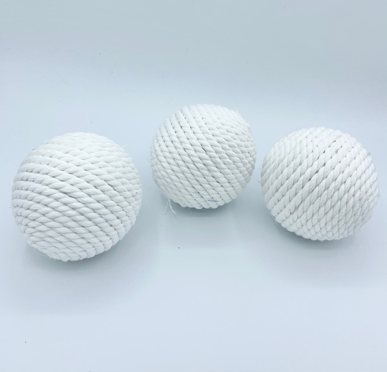 Puede incluir: Tres bolas de cuerda blancas, cada una con una textura y un patr&oacute;n diferentes. Las bolas est&aacute;n hechas de cuerda natural y son perfectas para agregar un toque de estilo n&aacute;utico a cualquier habitaci&oacute;n.