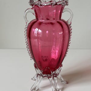 Antique English Victorian Cranberry Glass Trumpet Urn Vase With Clear Applied Rigaree Handles, Ruffle Rim & Clear Multi Toe’d Footed Base.