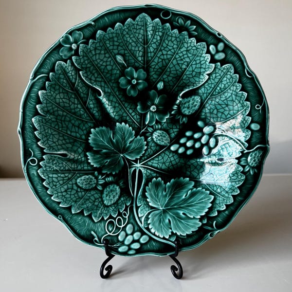 Piatto piccolo antico in maiolica verde scuro lucida con motivo a tralci, foglie e grappoli d'uva, diametro 20 cm. Un pezzo da collezione, perfetto da esporre in vetrina o a parete.