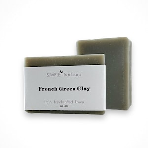May include: Two bars of green clay soap with a white label that reads "SIMPLE Traditions French Green Clay fresh, handcrafted, luxury".