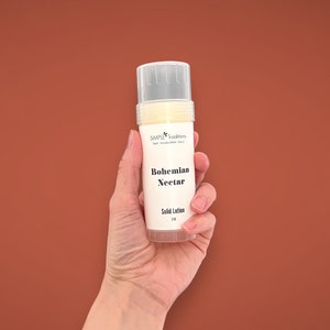 May include: A white tube of solid lotion with a label that reads "SIMPLE Traditions" and "Bohemian Nectar Solid Lotion 3 oz".