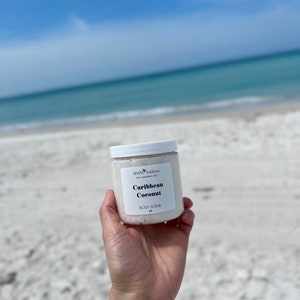 May include: A white jar of Caribbean Coconut body scrub with a white label that says "Simple Traditions" and "Caribbean Coconut Body Scrub".