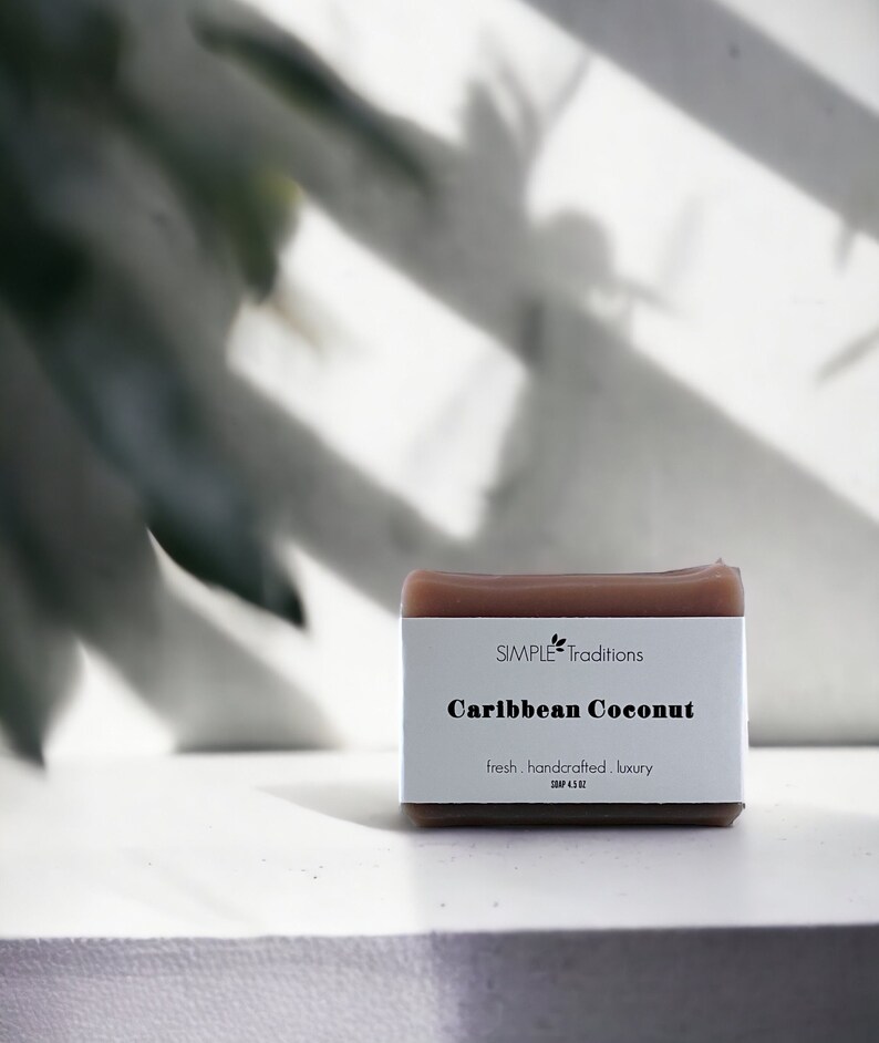 May include: A brown bar of soap with the text "SIMPLE Traditions Caribbean Coconut fresh. handcrafted. luxury. SOAP 4.5 OZ" printed on the label.